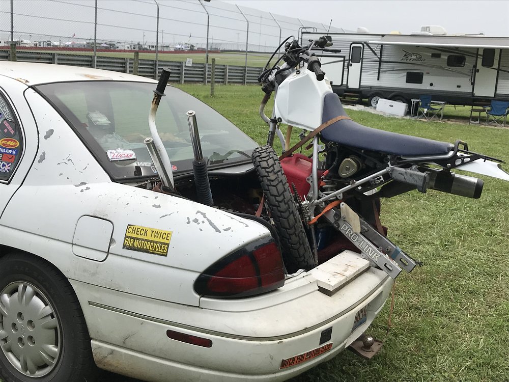 motorcycle stuffed into the trunk of a car
