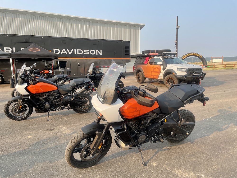 Harley Davidson Pan America adv bikes sit in the parking lot with a matching chase truck behind them