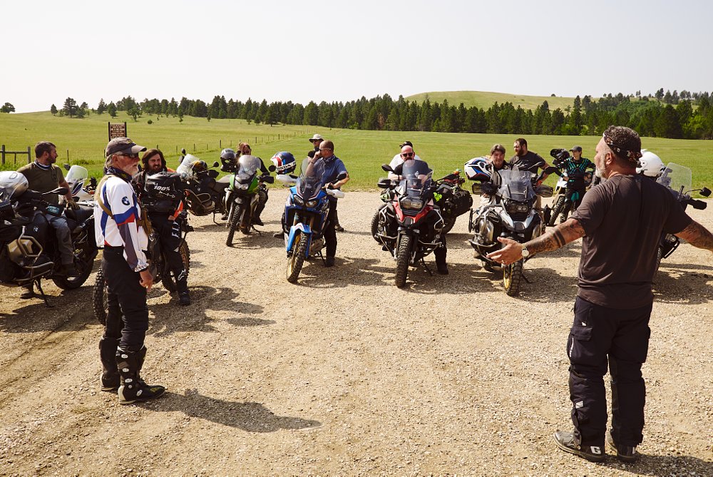 Two RawHyde instructors gather a group of students for some teaching in a big open field.