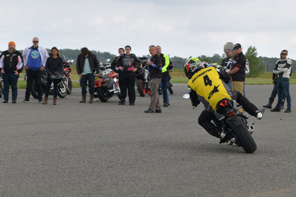 A YCRS instructor demonstrates a motorcycle drill while students watch at a distance