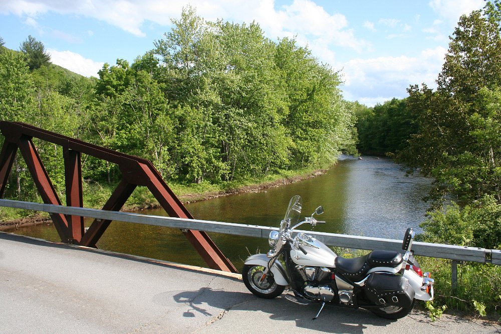 Cruiser parked on a bridge overlooking a rural stream