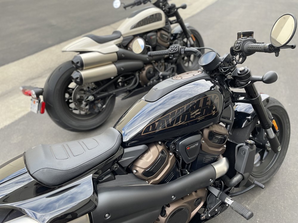 Two Sportster S motorcycles parked side by side, one has the mid control set up and one has the forward control foot pegs
