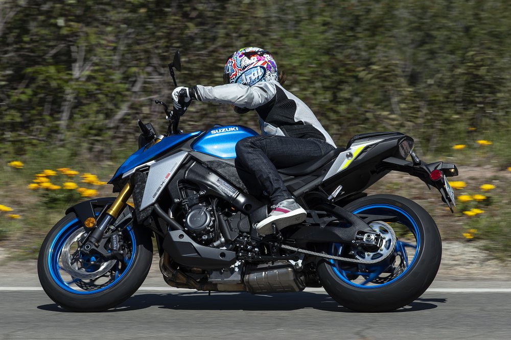 A side view of female rider leaned over in a corner on the GSX-S1000