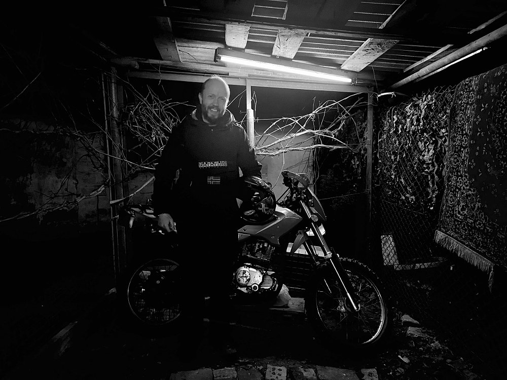 Kiran Ridley poses with his 200 cc Chinese motorcycle in Ukraine