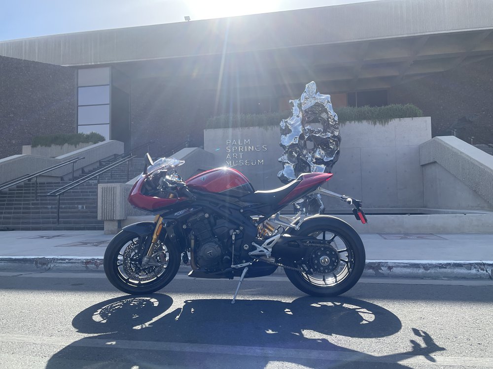 The Triumph sPEED tRIPLE 1200 RR parked in front of the Palm Springs modern art museum with sun rays