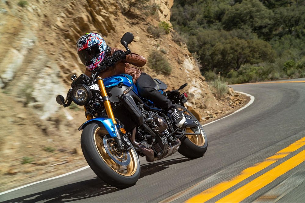 a female rider goes around a rocky canyon corner on the xsr900