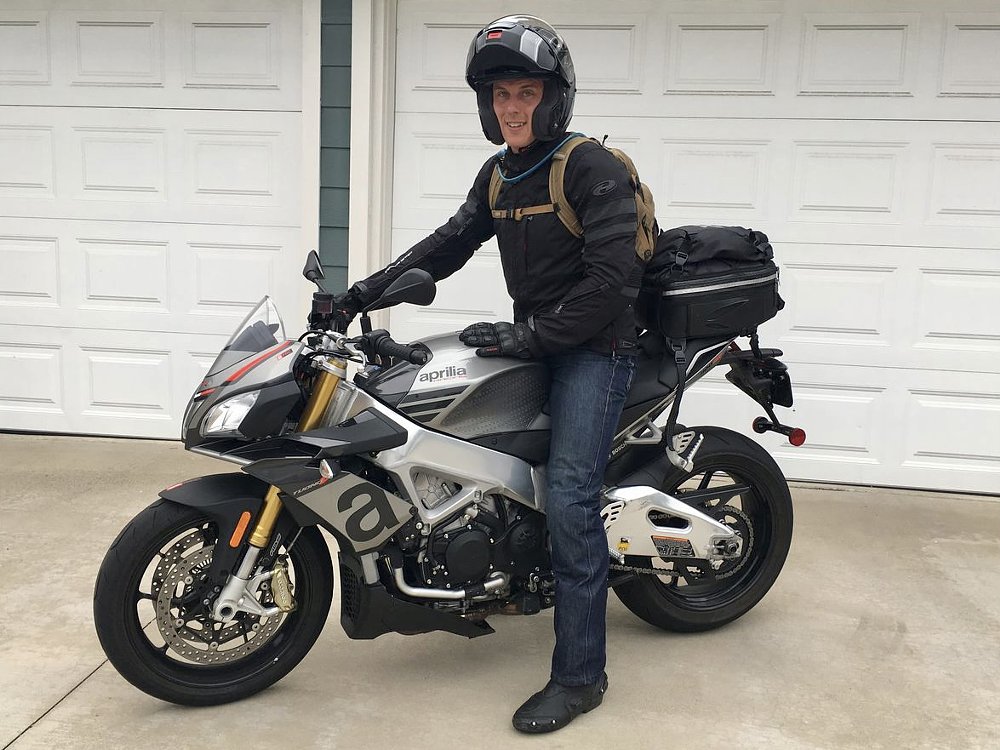 Ari on the Tuono 1100 wearing a hydration pack. 