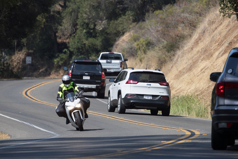 rider on a curvy road among car traffic