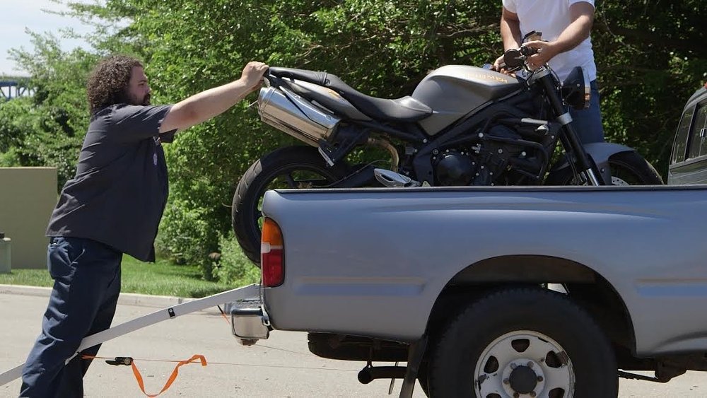Lemmy and another guy loading a motorcycle into a truck
