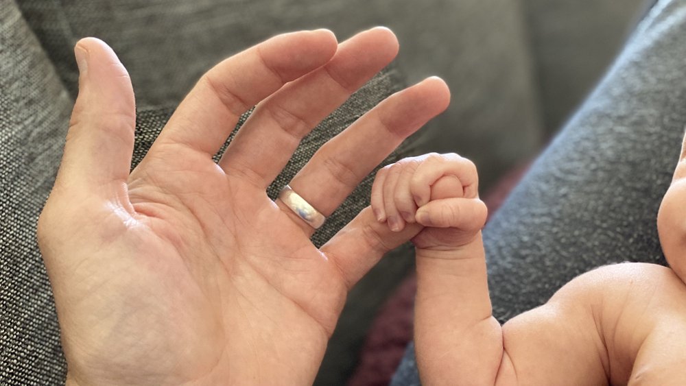 newborn baby's hand gripping his father's finger