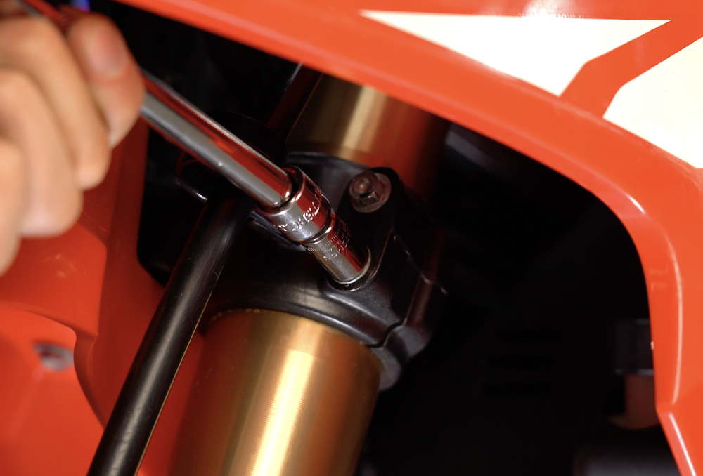 Tightening lower triple clamp bolt.