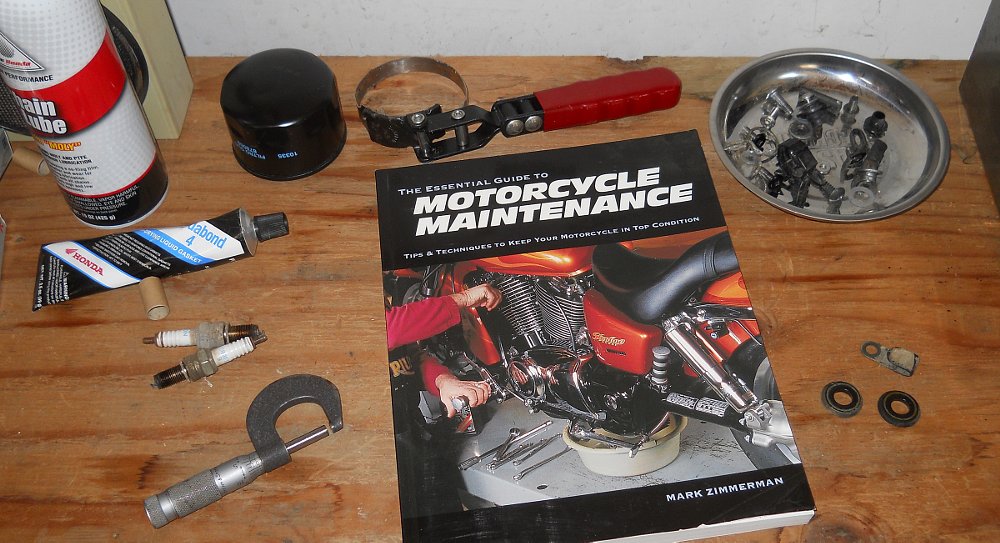 Motorcycle Maintenance book on a work bench with tools