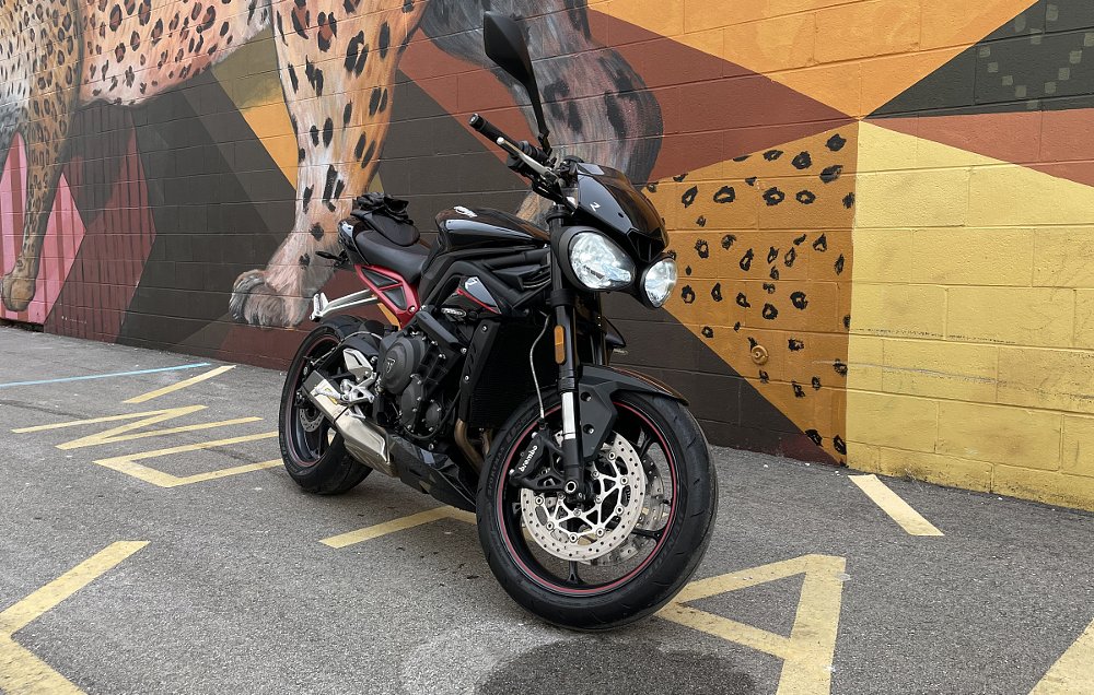Triumph Street Triple R parked in front of a mural