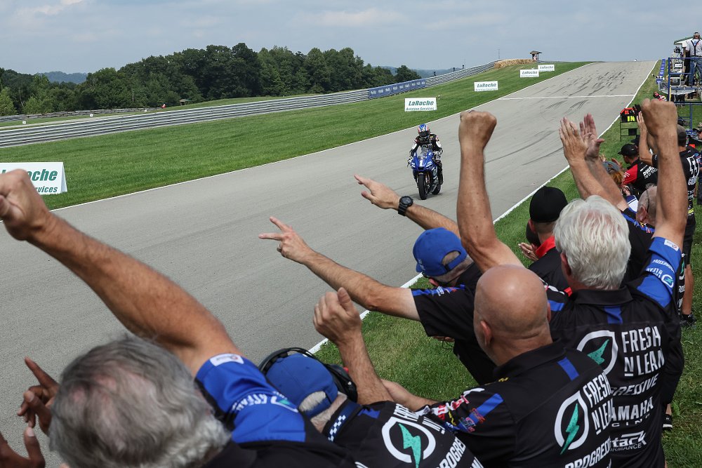 The Yamaha team cheers over the pit wall as Jake Gagne takes a win at Pittsburgh