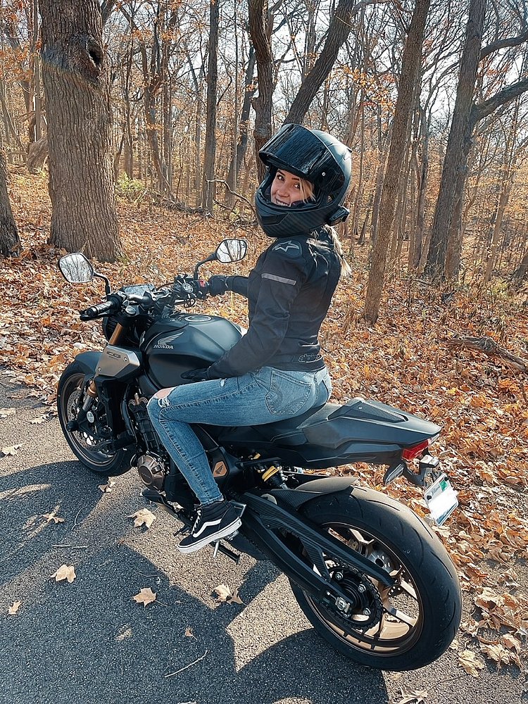 A photo of female rider Emily in full gear sitting on her Honda sportbike