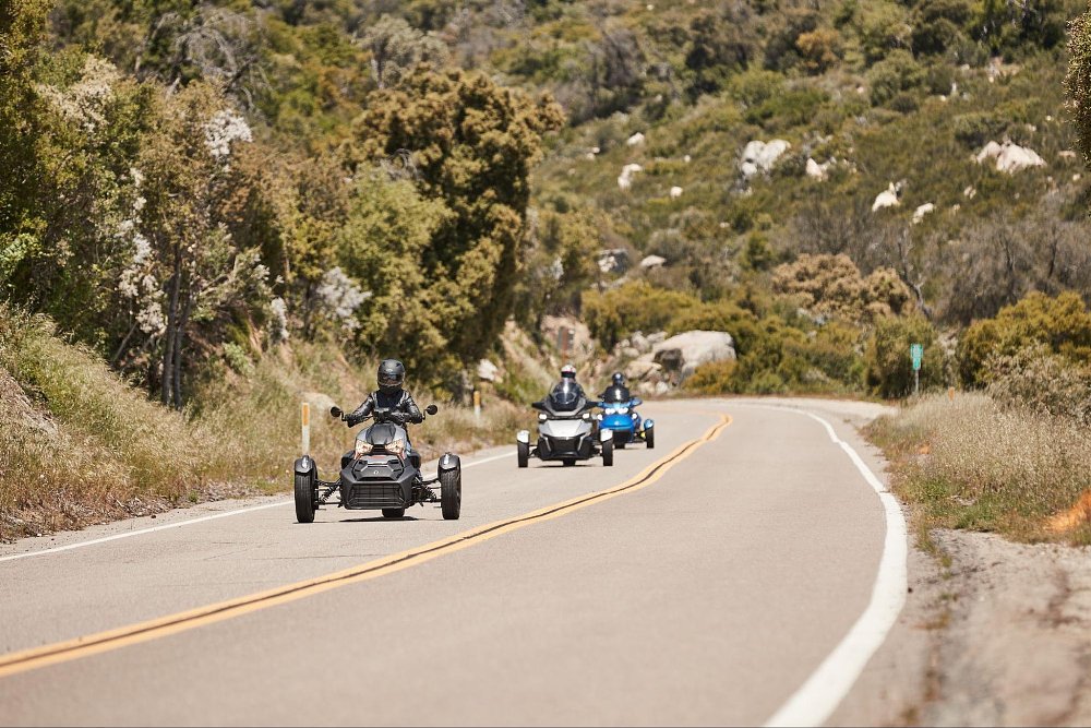 a group of ryker riders in a forest road
