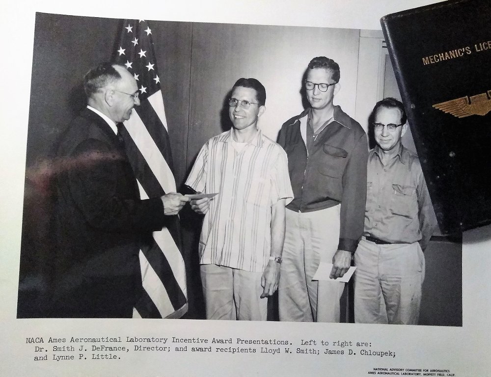 old photo of three me receiving an award and handshake