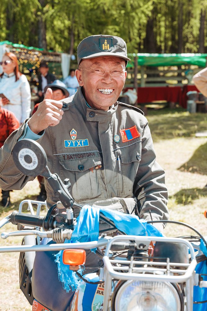 smiling ranger seated on motorcycle
