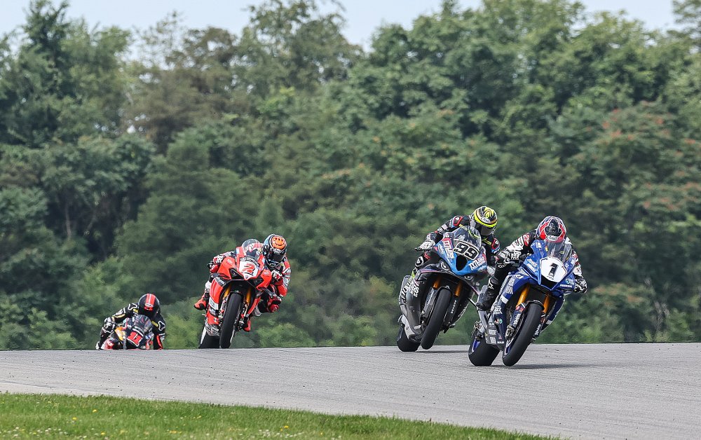 Gagne leading the front of the pack in Superbike race two at PIRC