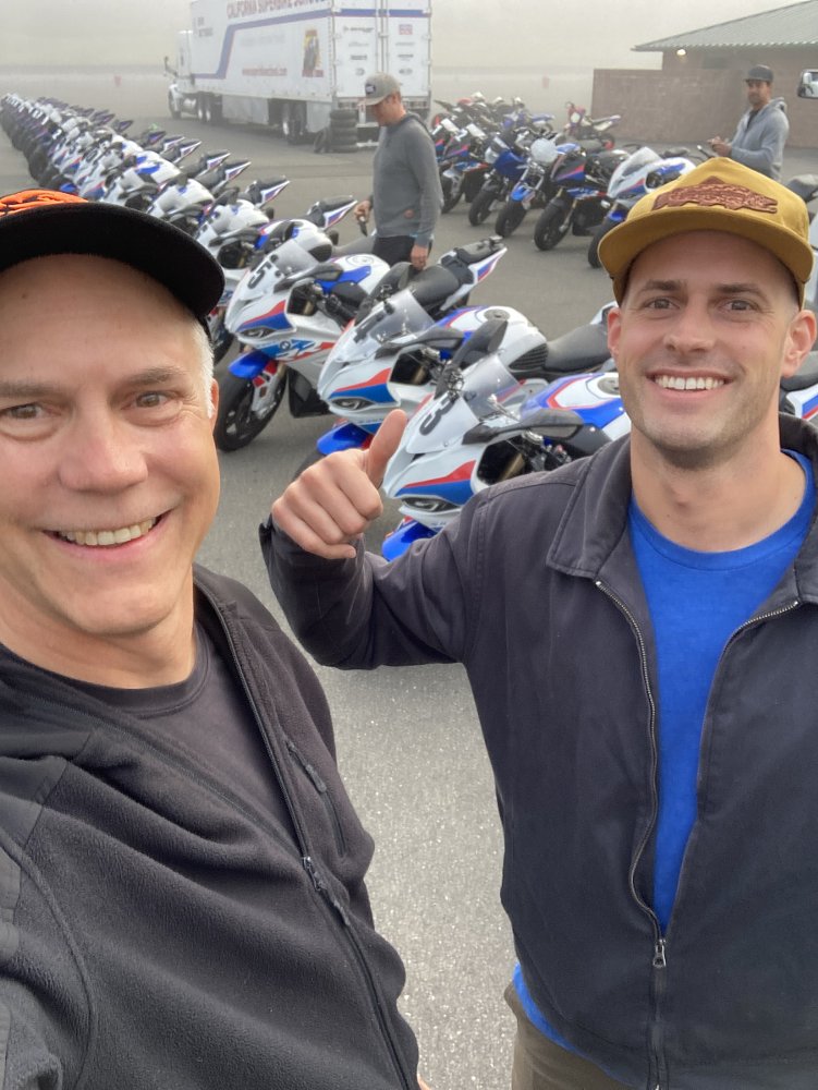 selfie of father and on in front of line of motorcycles