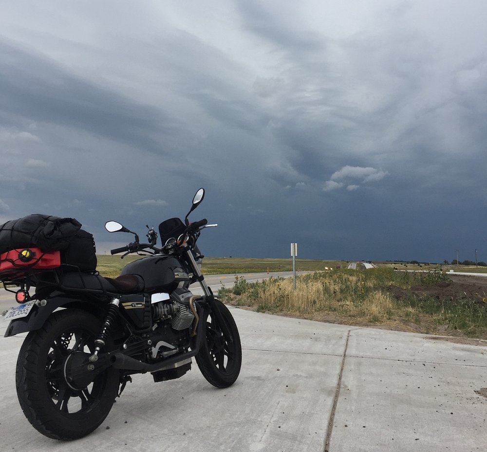 a storm on the horizon ahead of the motorcycle