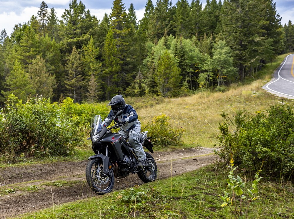 Honda Transalp rider pulling onto a dirt road from a paved road