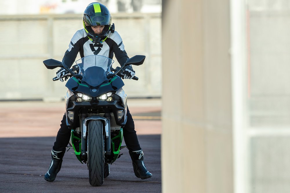 a female rider at a complete stop on the ninja 7 hybrid on the balls of her feet for touchdown