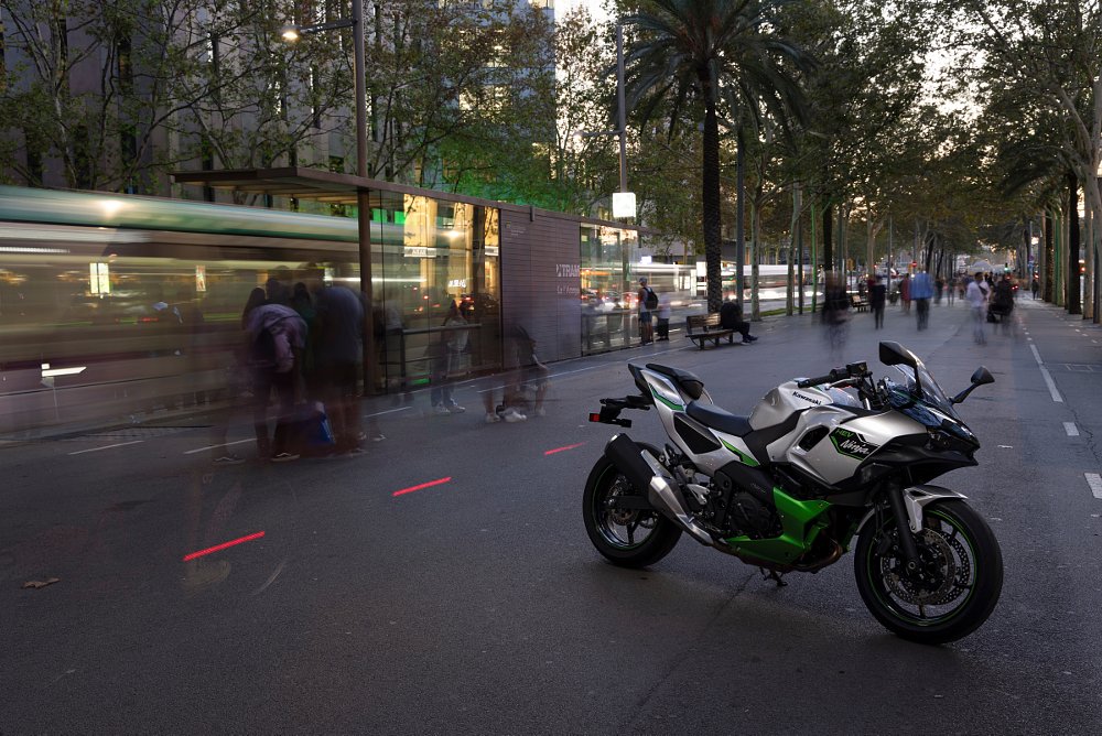 a nighttime shot of the ninja 7 hybrid with motion blur of traffic and pedestrians in background