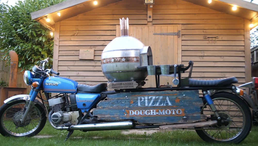 A Suzuki T500 Titan extended and with a spherical steel pizza oven mounted in the middle.