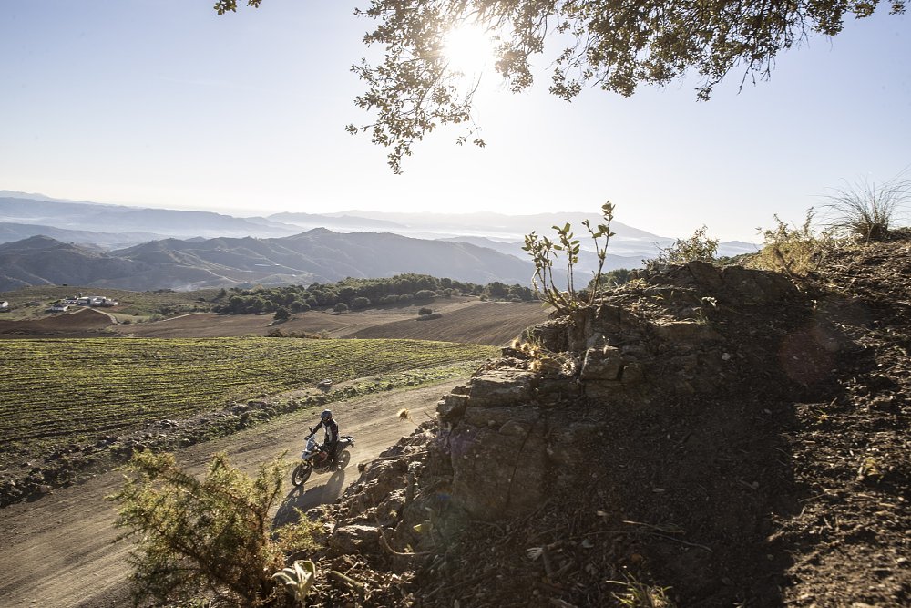 distant view of the Tiger 900 riding on a mountain dirt road in Spain