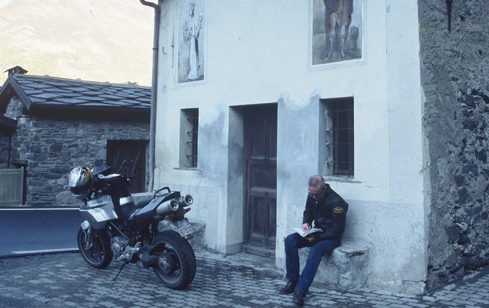 Mark Gardiner consults his notes on a village street in Italy with the Multistrada parked nearby