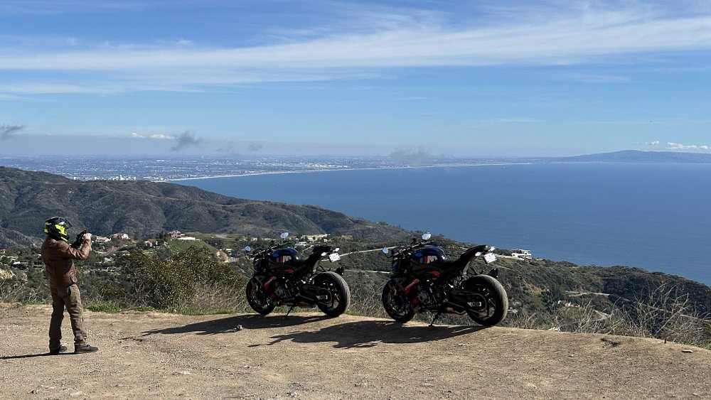 Two 2023 BMW M 1000 R motorcycles parked at an overlook of the Pacific Ocean in Malibu, California.