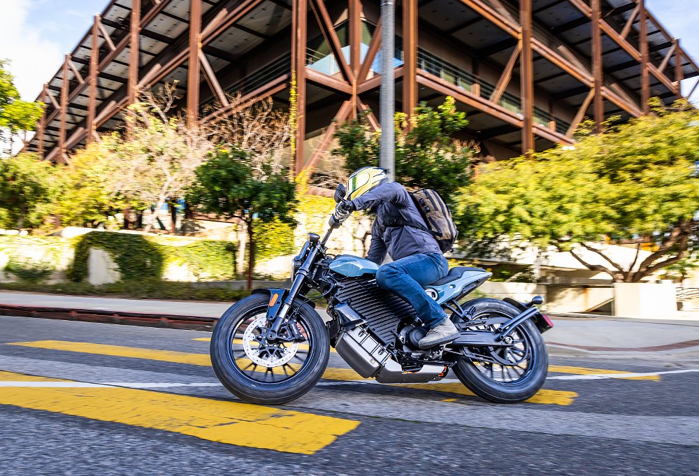 2024 LiveWire Del Mar rides in front of a tall building in a city.