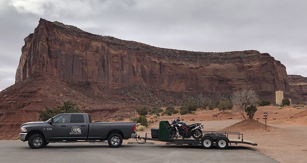 photo of truck hauling a trailer with motorcycles in the desert mountains