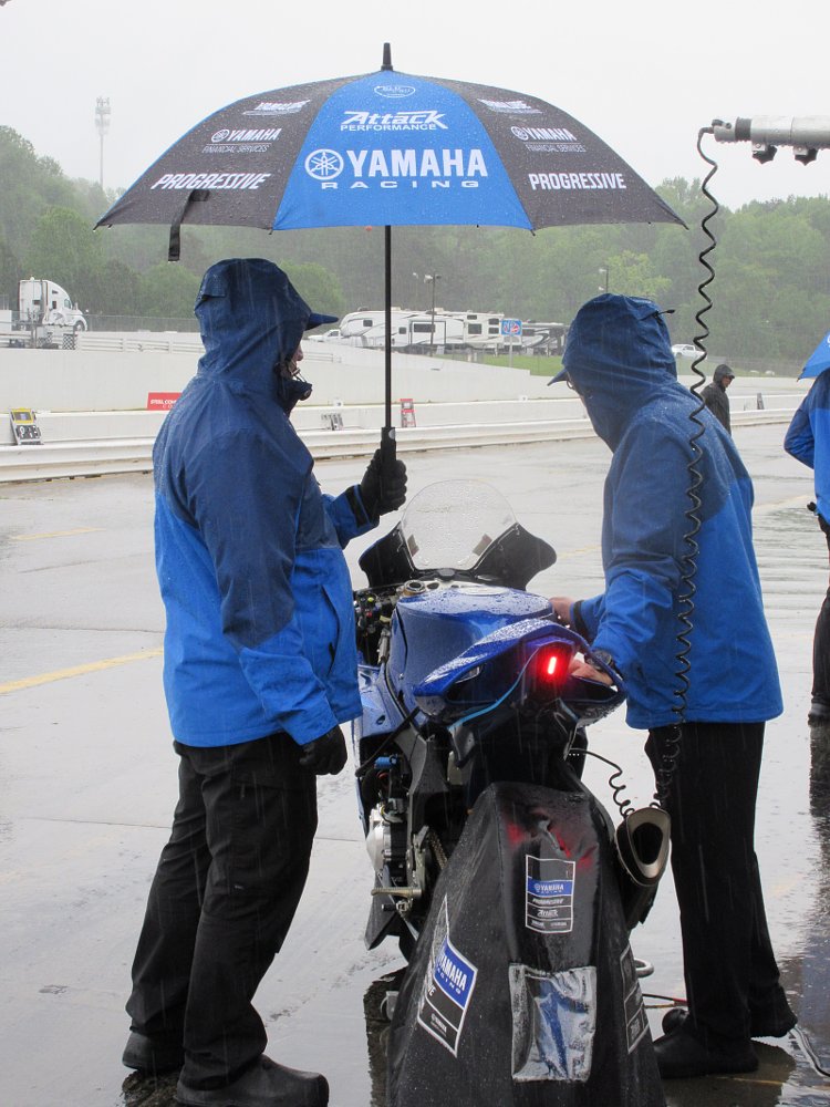 Attack Performance Yamaha crew members hold an umbrella over the R1 in the pits