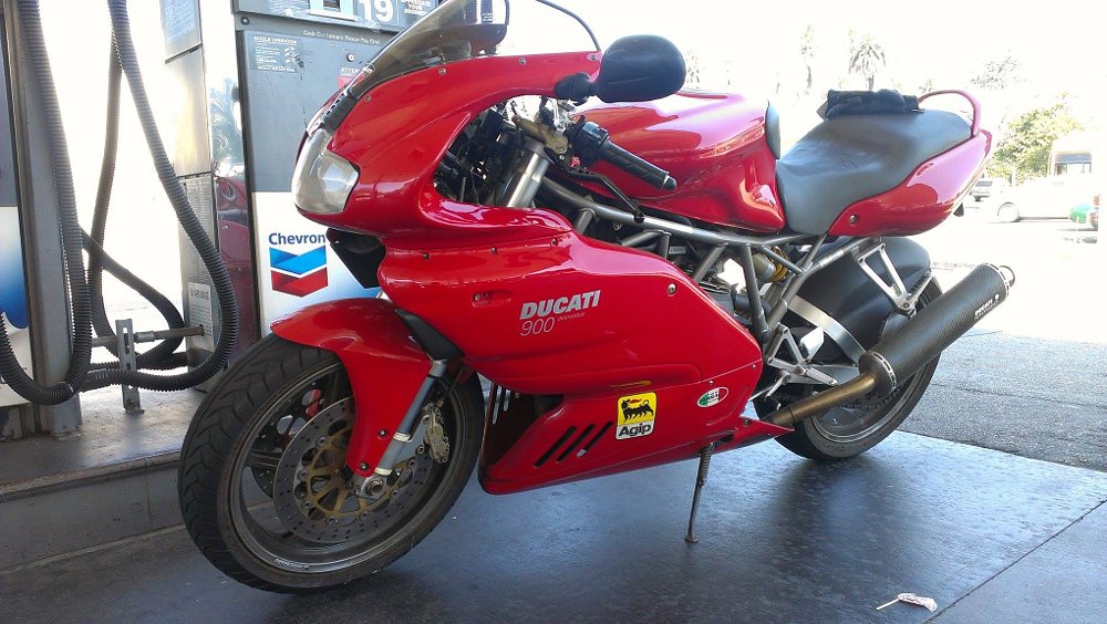 red Ducati 900SS at a gas pump