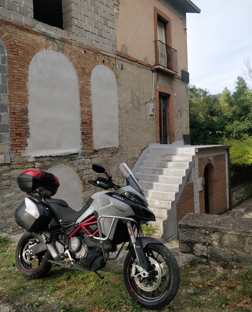 Ducati Multistrada parked outside an old brick building in Italy