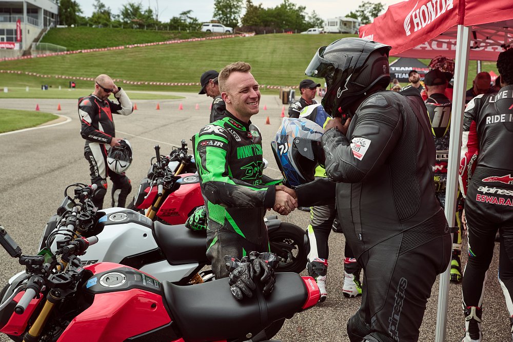 smiling riders shaking hands in the pits before the race