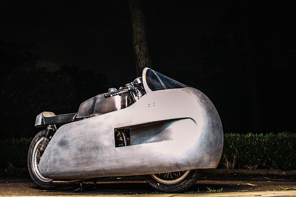 nighttime portrait of the custom Guzzi with large aluminum fairing