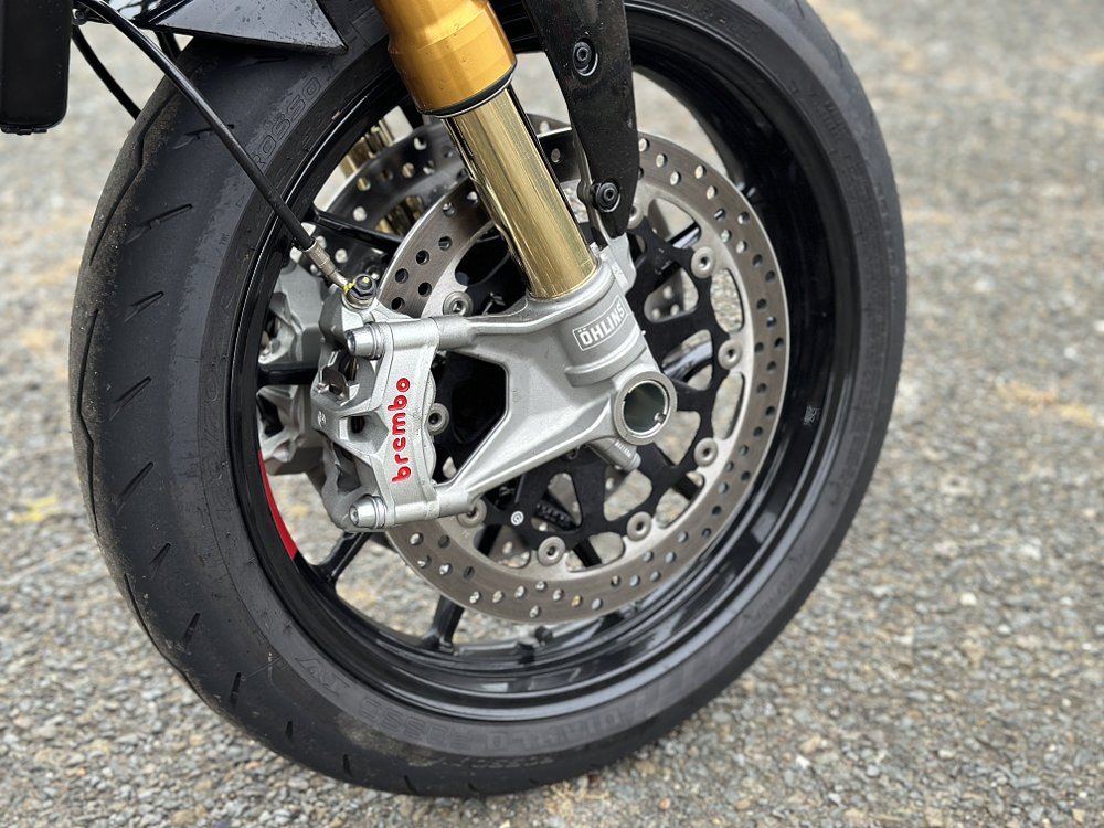 Detail image of the front wheel and brake of a 2024 Ducati Monster SP.