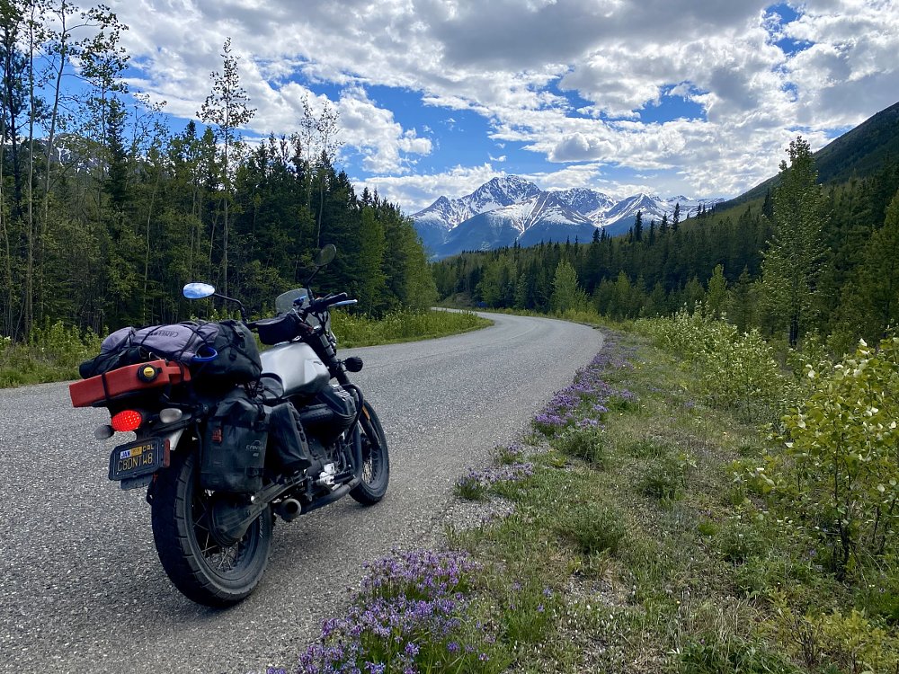 author's motorcycle parked along the Cassiar Highway, mountains in the distance