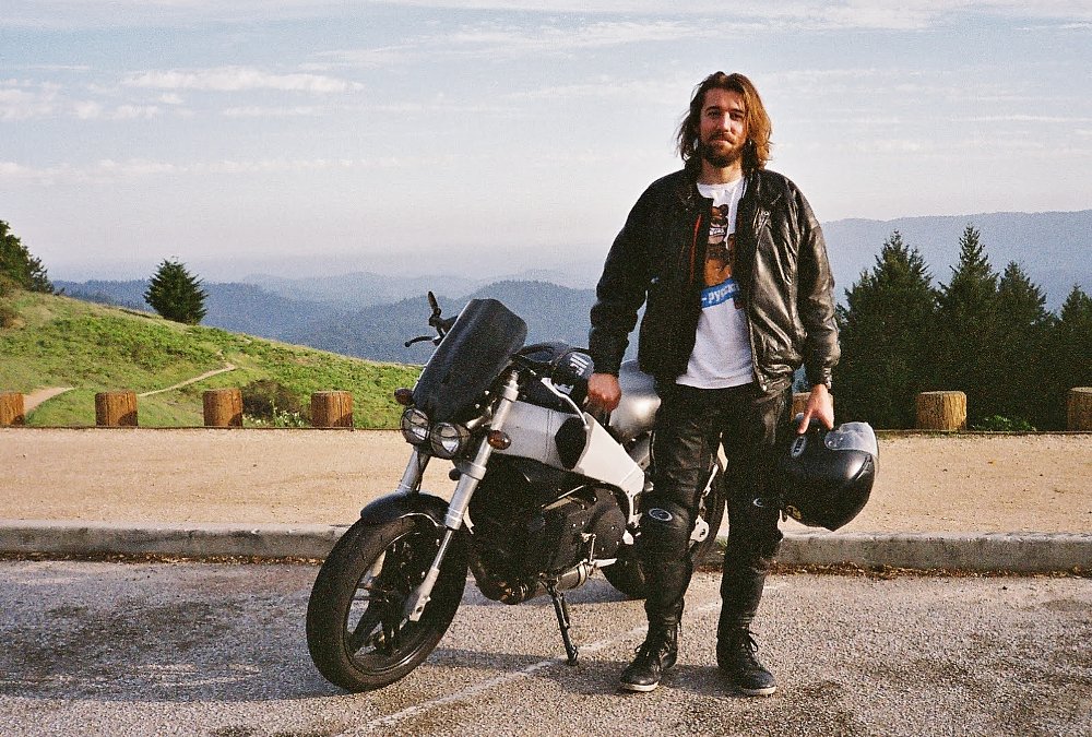 rider standing beside a black Buell XB9 CityX