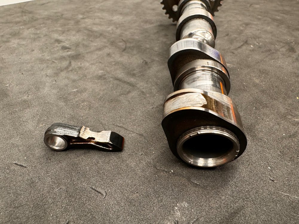 close up photo of removed camshaft and follower showing obvious wear