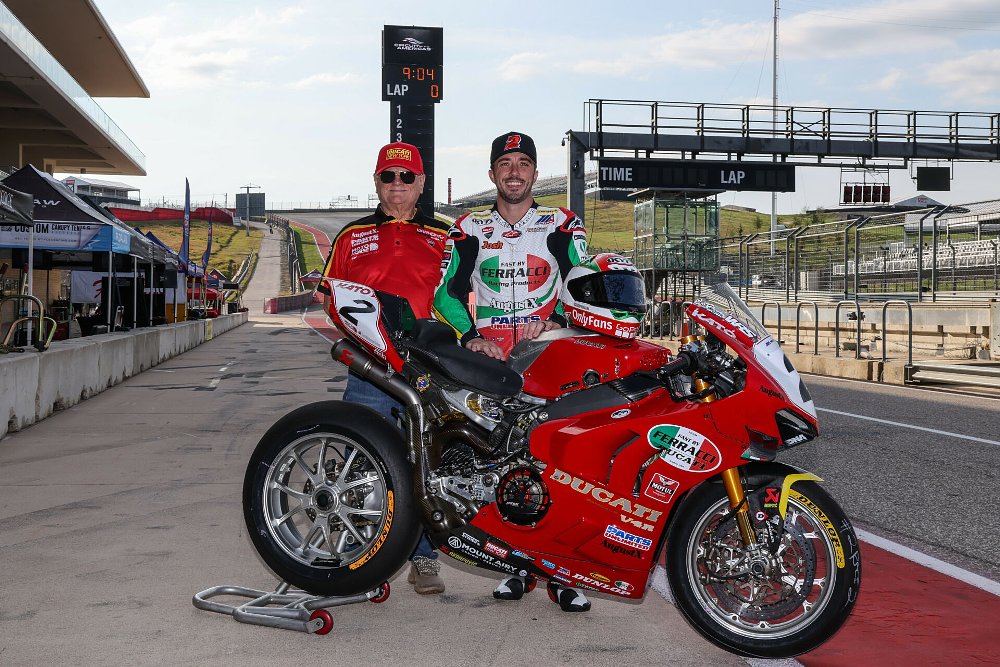 Herrin in Troy Corser leathers and his bike in throwback livery posing with Eraldo Ferracci at COTA