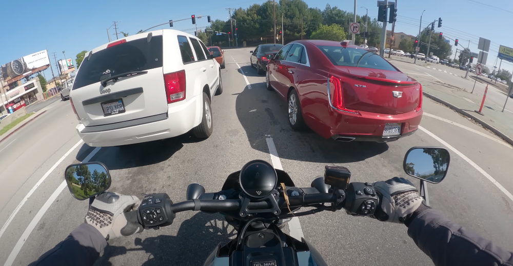Motorcycle filtering to the front of traffic at a stop light