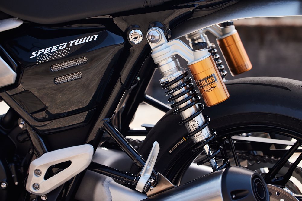 closeup photo of gold-colored Ohlins rear shock absorbers on the Speed Twin 1200 RS