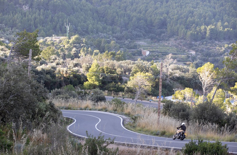 rider on a winding road in the distance on a Speed Twin 1200
