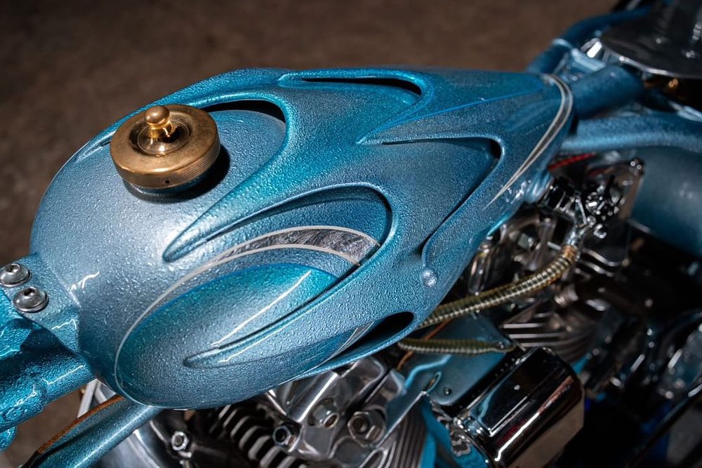 layers of metal on the blue fuel tank of the motorcycle