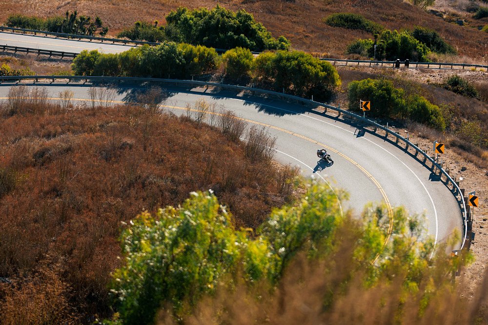 2024 BMW R 12 nineT seen from far away, riding on a mountain road.