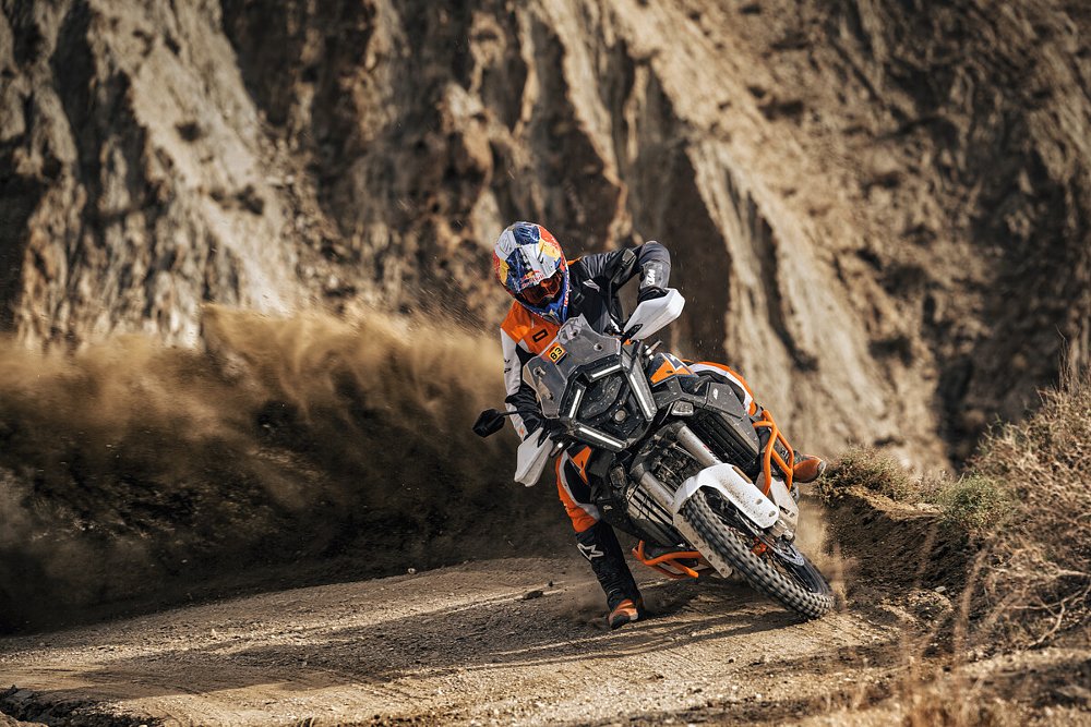 A rider throws up roost as he rides the Super Adventure R through a berm.